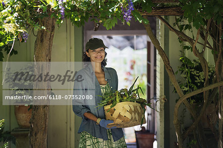 A young woman in a farmhouse kitchen, with large windows onto the garden.