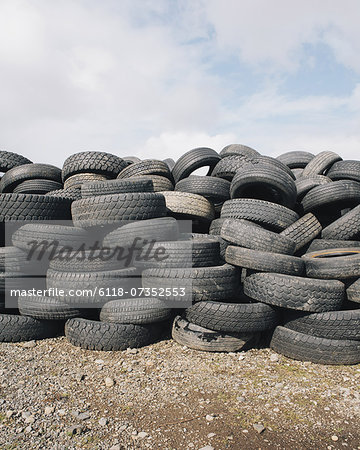 A stack of discarded rubber car tires, collected for recycling, or disposal.