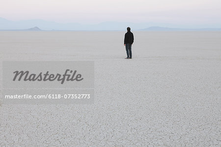 Man standing in vast, desert landscape Man standing in vast, desert landscape