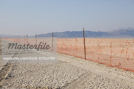 Fence barricade extending across the flat landscape, Black Rock Desert, Nevada, USA