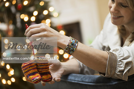 A young woman holding a pair of hand knitted baby booties. A young woman holding a pair of hand knitted baby booties.
