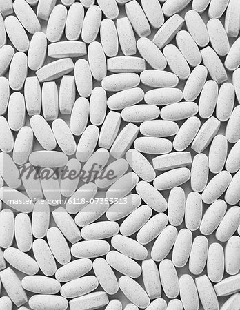 Vitamin C supplements, white oval tablets, taken for health reasons.