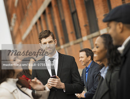 City life. A group of people on the go, keeping in contact, using mobile phones, and talking to each other. Men and women, professionals in a group. City life. A group of people on the go, keeping in contact, using mobile phones, and talking to each other. Men and women, professionals in a group.