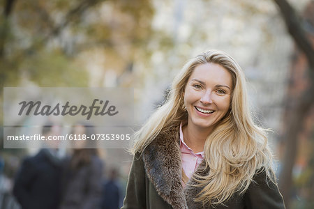 Group walking in urban park, woman in front