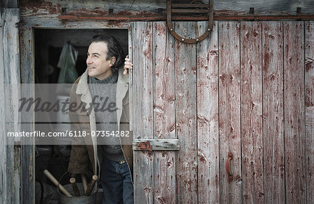 An organic farm in upstate New York, in winter. A man at an open barn door.