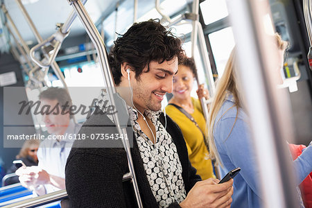 New York City park. People, men and women on a city bus. Public transport. Keeping in touch. A young man checking his cell phone. New York City park. People, men and women on a city bus. Public transport. Keeping in touch. A young man checking his cell phone.