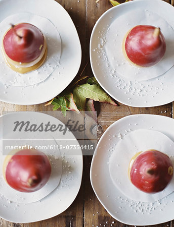 Tabletop viewed from above. Four plates with dessert. Pears dipped in sauce. Tabletop viewed from above. Four plates with dessert. Pears dipped in sauce.