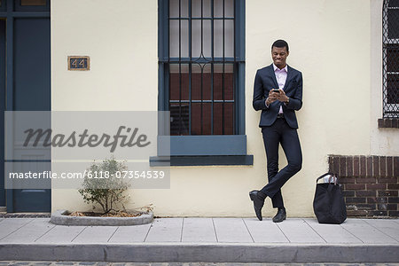 New York city street life.Young people outdoors on the city streets in springtime.  A man leaning against a wall.