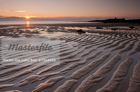 Ripples of sand near Dunstanburgh Castle in Embleton Bay at sunrise, Northumberland, England, United Kingdom, Europe Ripples of sand near Dunstanburgh Castle in Embleton Bay at sunrise, Northumberland, England, United Kingdom, Europe