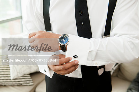 Close-up of Groom putting on Cuff Links for Wedding