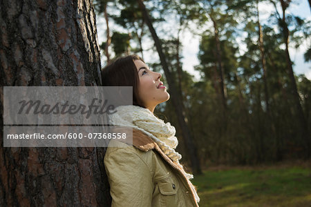 Young Woman Leaning against Tree Trunk, Mannheim, Baden-Wurttemberg, Germany