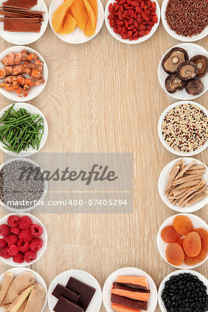 Healthy superfood abstract border over oak wood background