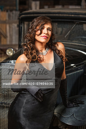 Smiling beautiful woman leaning on antique car