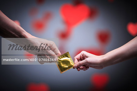 Two hands holding a condom