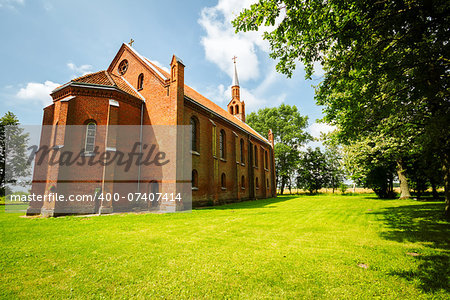 Small gothic style church on a green grass in Lithuania