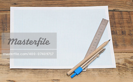 Still life photo of engineering graph paper with pencil, compass and metal ruler blank to add your own design