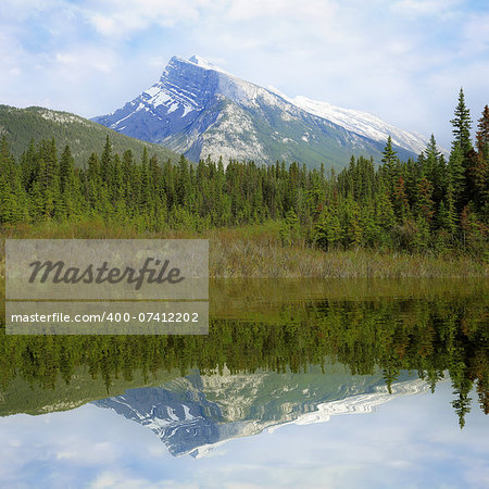 Rundle mountain and its reflection in Vermilion lake water.