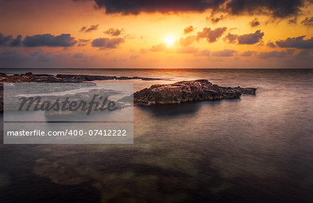 sunset over the sea and rocky coast