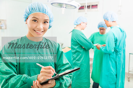 Smiling woman surgeons writing patient operating records