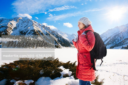 Young woman take a walk on winter mountain slope (Big Almaty Lake, Kazakhstan)