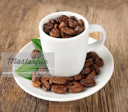 Coffee beans with leaf on wooden tables. Coffee drinks.