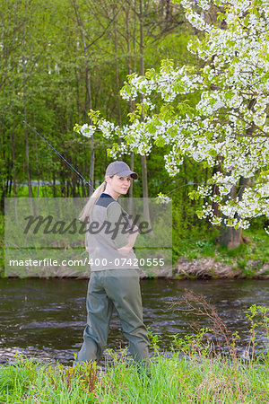 woman fishing by the river in spring