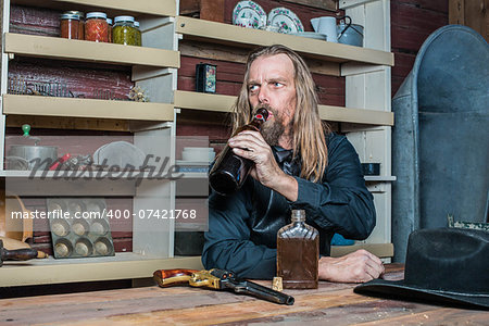 Drunk Western Man Looks Into the Distance as he Sits at Table