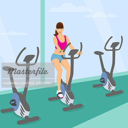 Smiling young woman with brown hair uses a bicycle in the gym for a good mood and slim body