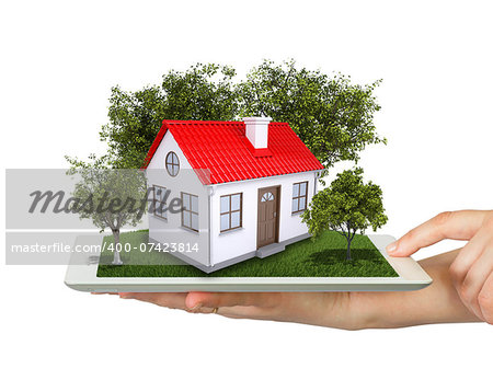 Hands holding a tablet pc and small house with land. Isolated on white background