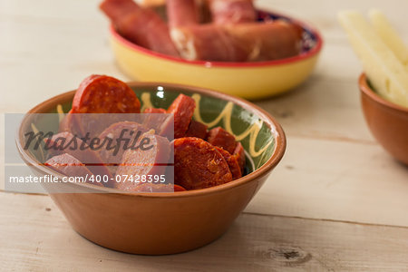 Tapas, chorizo, and cured ham on a wooden table