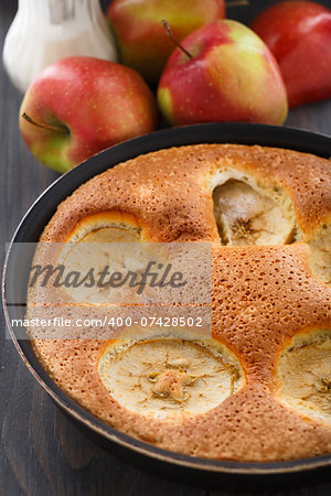 Freshly baked apple pie with apples on background