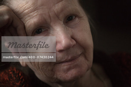 old woman thinking in the dark, close up