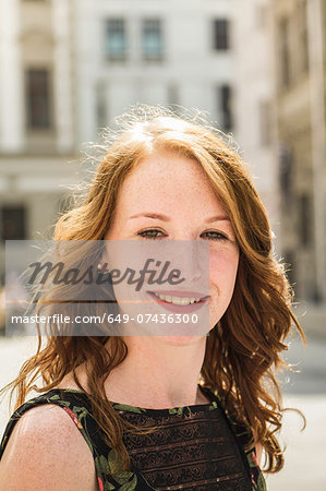 Portrait of young woman standing in town