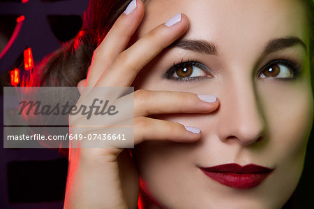 Close up portrait of smiling young woman with hand on face