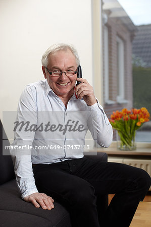 Senior man at home talking on mobile phone
