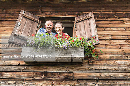 Portrait of couple at chalet window, Achenkirch,  Tyrol, Austria