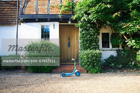 Toy scooter parked outside cottage