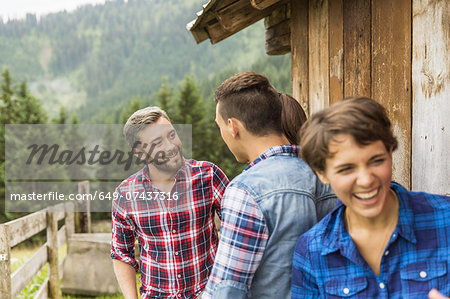 Group of friends chatting behind wooden shack