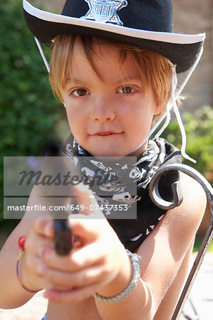 Boy in sheriff hat with gun