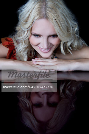 Woman looking at reflection of herself on table