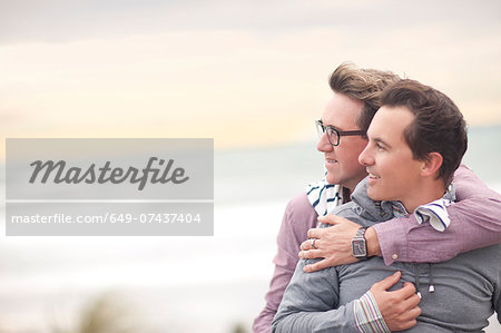 Gay couple hugging on beach