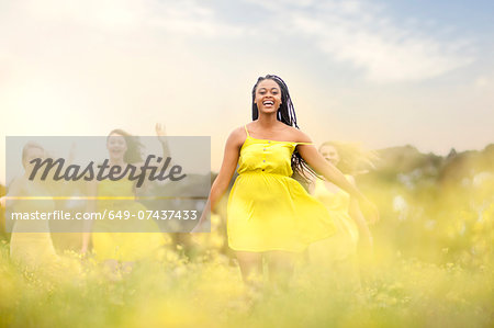 Girls in yellow dancing on meadow
