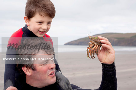 Father holding crab with son