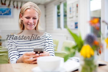 Young woman in cafe looking at mobile phone