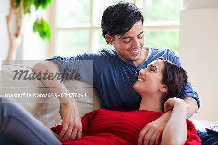 Young couple reclining on living room sofa