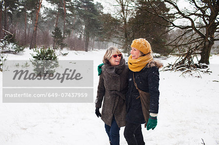 Mother and daughter walking in snow