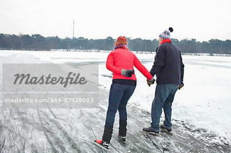 Couple ice skating, holding hands