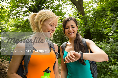 Women out walking in forest, checking the time