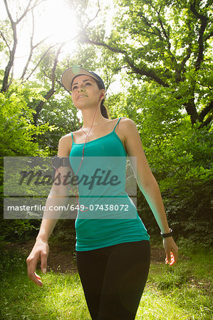 Woman walking in forest, listening to music