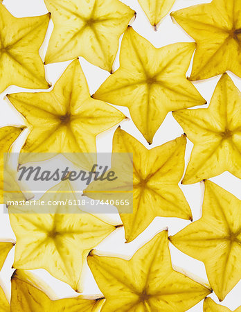 Slices of organic starfruit on white background